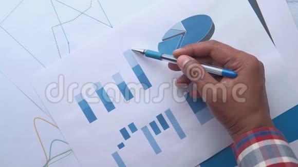办公桌上人手分析图表的俯视图视频的预览图