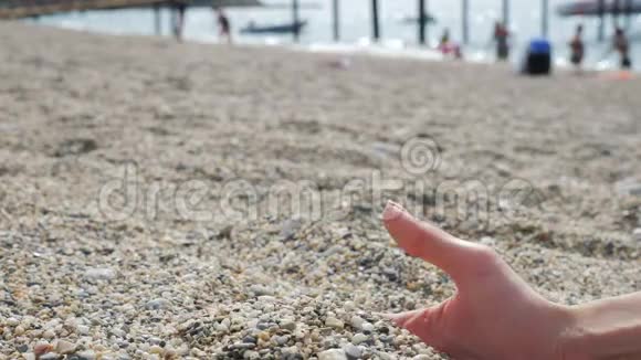 沙滩上有小石子的女性手视频的预览图