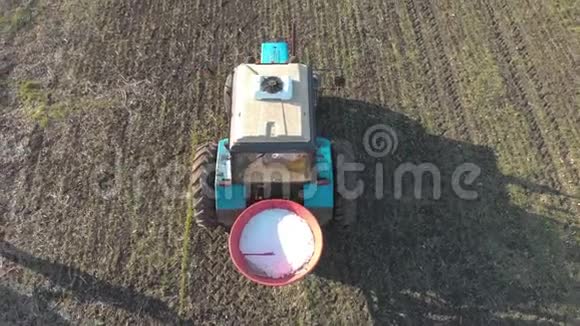 拖拉机在绿田中播撒人工肥料农民用氮肥和钾肥耕地视频的预览图