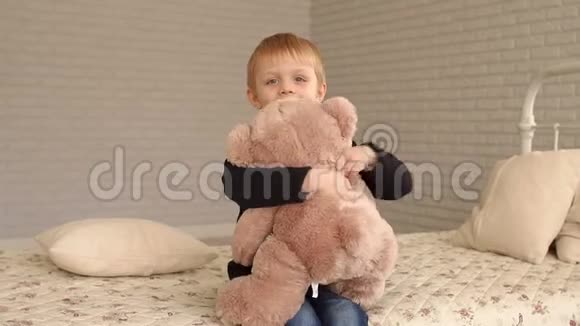 一个金发小男孩和他最喜欢的泰迪熊在家的画像视频的预览图