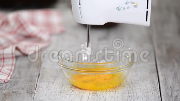 烹调糖果逐渐加入热糖浆到蛋黄视频的预览图