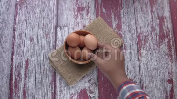 木桌上碗中鸡蛋的俯视图视频的预览图
