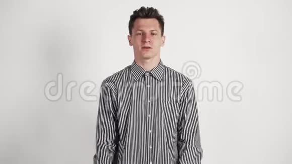 年轻的白种人的外表在他的衬衫上表现出他的喜悦和胜利的情绪在白色背景上视频的预览图