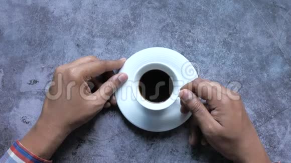 男子手在黑瓦上喝茶的俯视图视频的预览图