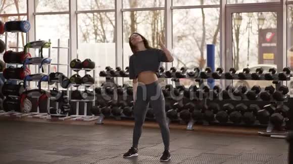 坚定的健身女性在现代健身房热身的完整镜头肌肉女运动员在激烈的比赛前热身视频的预览图