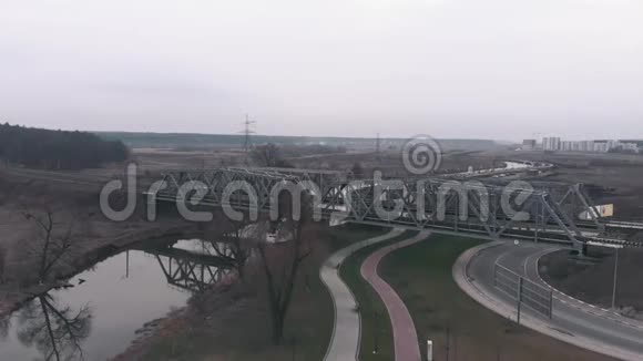 无人机驾驶飞机飞越铁路公路与河流和旅游长廊有步行道和码头的河流鸟瞰图视频的预览图