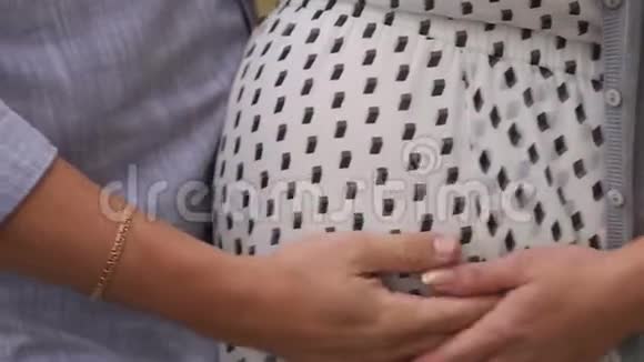 特写丈夫在户外轻轻抚摸怀孕妻子的肚子视频的预览图