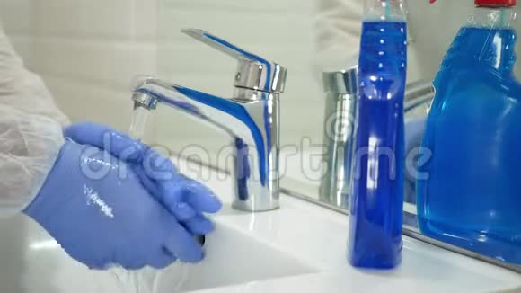 戴防护手套的人用清水洗手视频的预览图