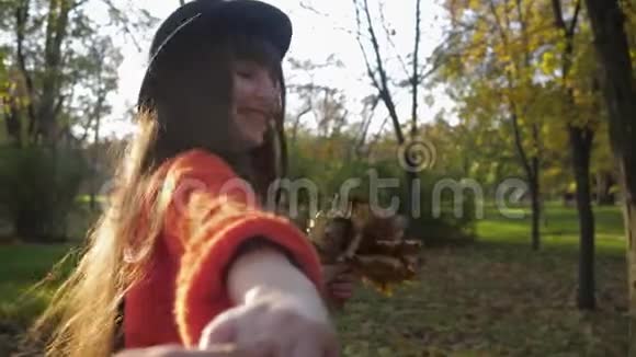秋天公园里漂亮的女孩戴帽子的年轻风趣的女人在周末的时候欢快地奔跑牵着朋友的手视频的预览图