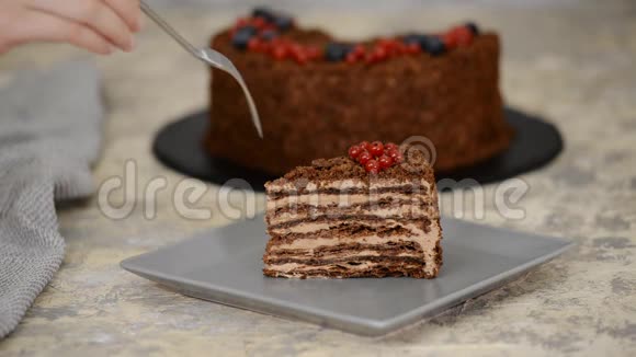 一块法国巧克力拿破仑蛋糕的膨松糕点和浆果在盘子特写吃巧克力蛋糕视频的预览图
