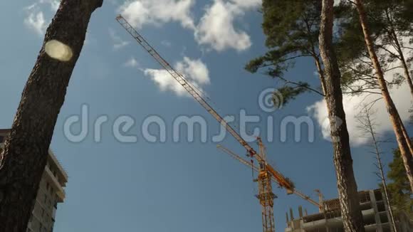 高吊车在有房子的建筑工地施工建造建筑摩天大楼的建造过程视频的预览图