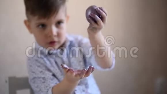 一个小孩正在玩一个彩绘的复活节彩蛋视频的预览图
