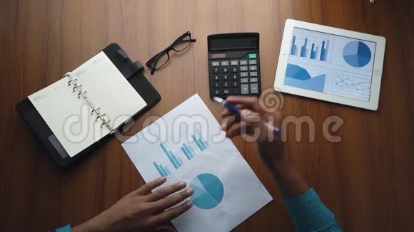 办公室桌上的人手分析图表视频的预览图