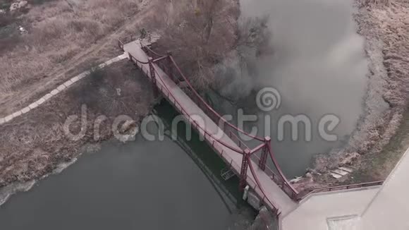 过江人行桥鸟瞰图无人机用小桥飞过城市码头视频的预览图