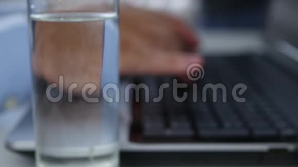 桌上有一杯水的人完成他的工作并关上盖子视频的预览图