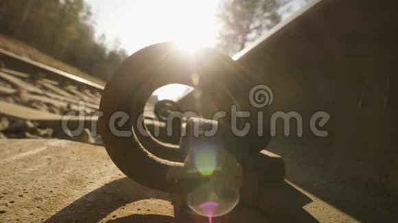 日落背景下铁轨穿过紧固件的宏观镜头视频的预览图