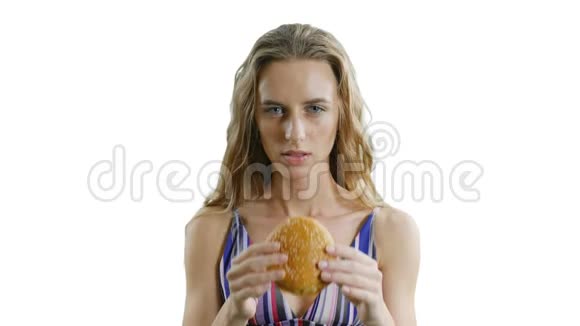 年轻瘦瘦的漂亮女人正在白色背景下吃汉堡包瘦女孩饿了视频的预览图