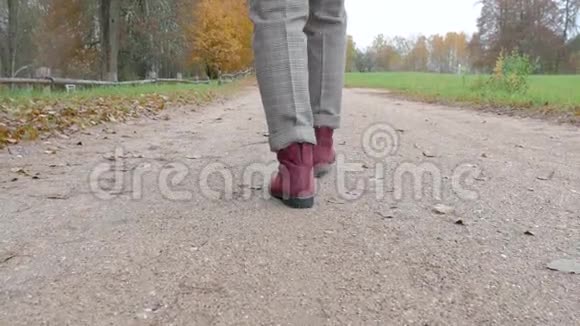 阴天时女性的双腿沿着沙道行走在公园里视频的预览图