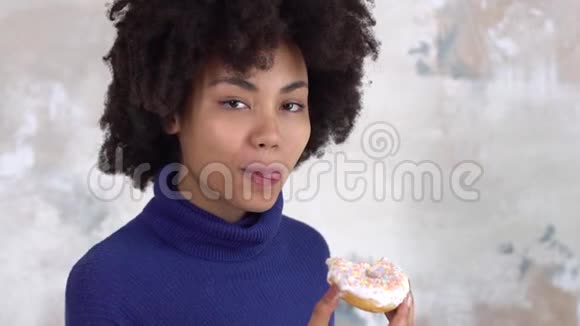 非洲年轻女子被隔离在白色咬着的甜甜圈上快乐视频的预览图