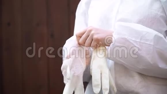穿白西装的医生在白色背景上戴上防护手套防止冠状病毒视频的预览图