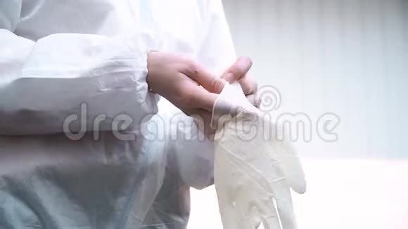 穿白西装的医生在白色背景上戴上防护手套防止冠状病毒视频的预览图