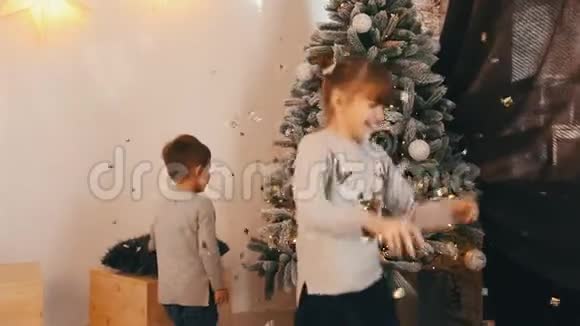 两个快乐的孩子在玩旋转和嘲笑圣诞树视频的预览图
