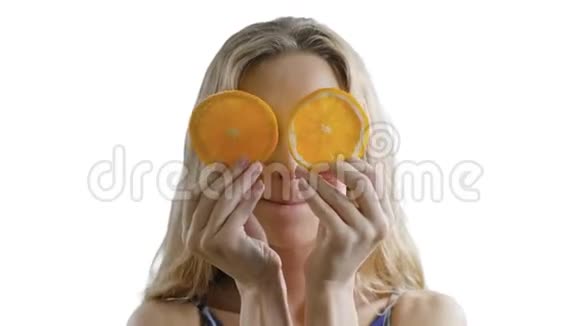 年轻漂亮的女孩在白色的背景上手里拿着橘子微笑快乐健康瘦女人期待视频的预览图