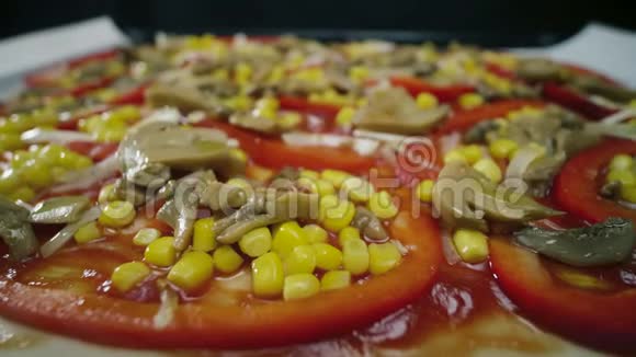 自制纯素披萨配上蘑菇胡椒玉米和橄榄在餐桌上旋转视频的预览图