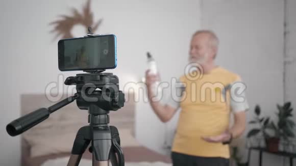 现代收入有博客的老年男性Impactencers通过录制视频为他的订阅者做广告视频的预览图