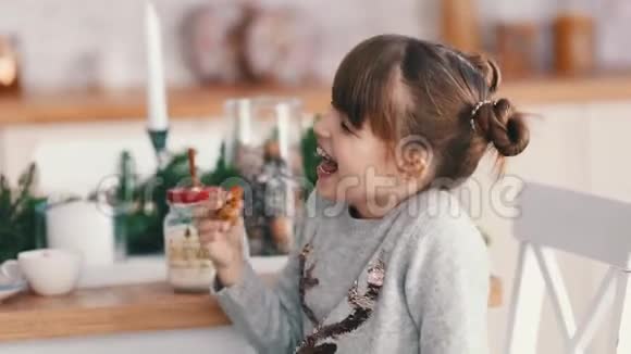 圣诞节的早晨可爱的小女孩品尝饼干视频的预览图