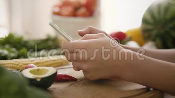 女人在厨房里用手机视频的预览图