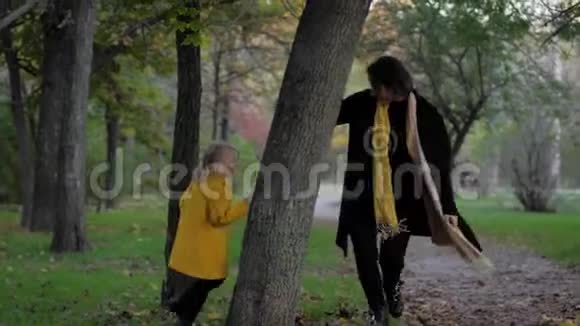 家庭度假快乐的母亲在秋天的公园里散步和她美丽的女孩子玩捉迷藏视频的预览图