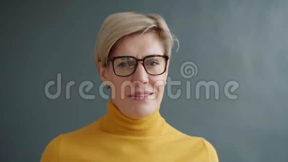 一幅成年女性的画像她留着短发戴着时髦的眼镜看着镜头视频的预览图