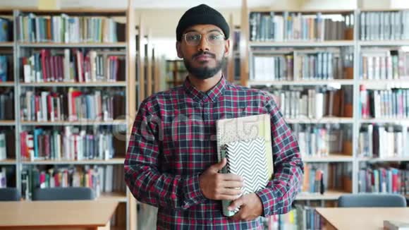 严肃的非裔美国人学生在大学图书馆拿书的肖像视频的预览图