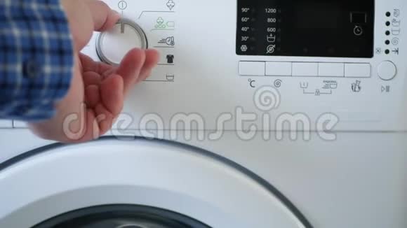 男人使用洗衣机设定程序温度水平和推动启动按钮视频的预览图