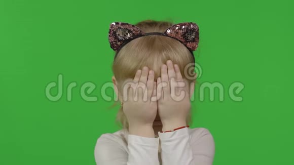 戴着猫头巾的女孩把脸藏在手后面四岁快乐的孩子视频的预览图