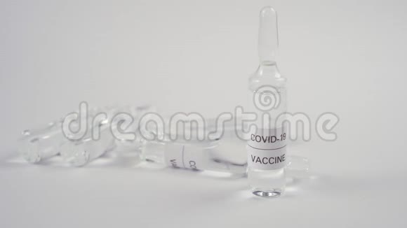 冠状病毒疫苗和COVID19一只手戴着蓝色防护手套把安瓿和药放在白色桌子上视频的预览图