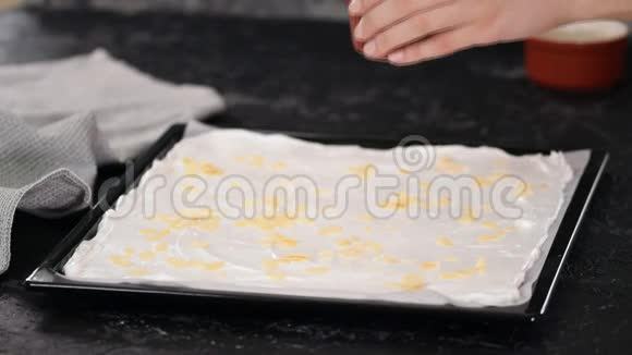 糕点厨师做一个月桂卷蛋糕洒杏仁片在月桂基地视频的预览图