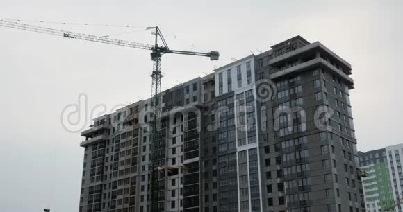 现代高层住宅综合体在建用巨大吊车施工过程建筑工人在建筑工地工作视频的预览图