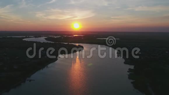 俄罗斯河岸上的村庄日落时分无人机拍摄的视频视频的预览图