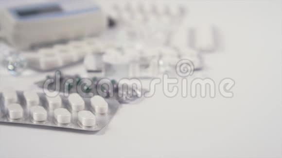 装有冠状病毒疫苗的玻璃安瓿放在白色桌子上桌上有医疗设备和药丸视频的预览图