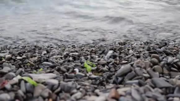 平静宁静的海浪拍打着鹅卵石的夏日海滩海岸视频的预览图