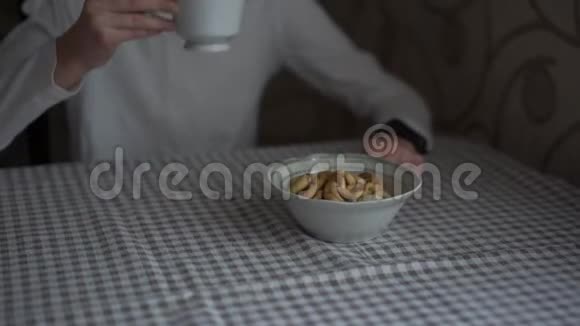 穿着白破衬衫的女孩喝着带百吉饼的茶视频的预览图