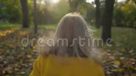 无忧无虑的童年微笑的女孩在秋天公园散步时快乐地跑到她慈爱的母亲身边幸福的概念视频的预览图
