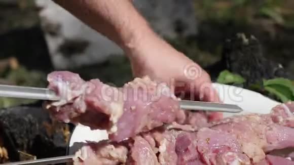 人在扦子上刺肉厨师在木炭烤架上煮肉准备烧烤肉烹饪理念户外度假视频的预览图