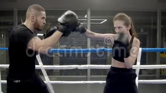 女青年在健身房与教练拳击视频的预览图