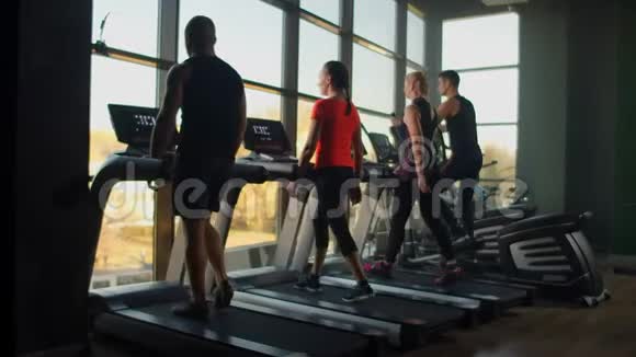 人们在健身房训练使用跑步机和椭圆交叉或在健身房训练视频的预览图