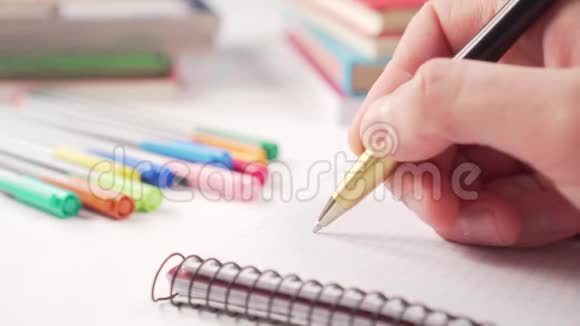 用黑色金色钢笔在白色桌子上的笔记本上手工书写里面有多种颜色的创意和书籍的学习用品视频的预览图