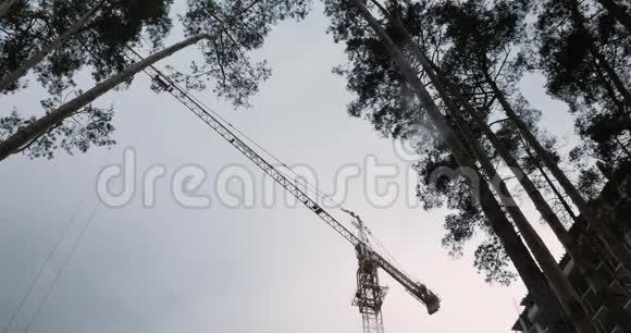 建筑工地绿化区高施工吊车工程施工吊车吊运大型建筑材料塔楼视频的预览图