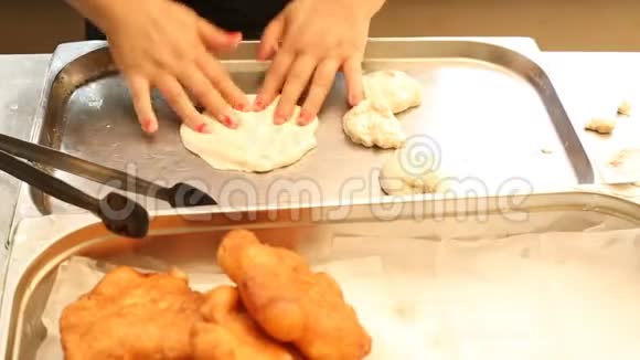 在厨房里用女性手做甜甜圈面团视频的预览图